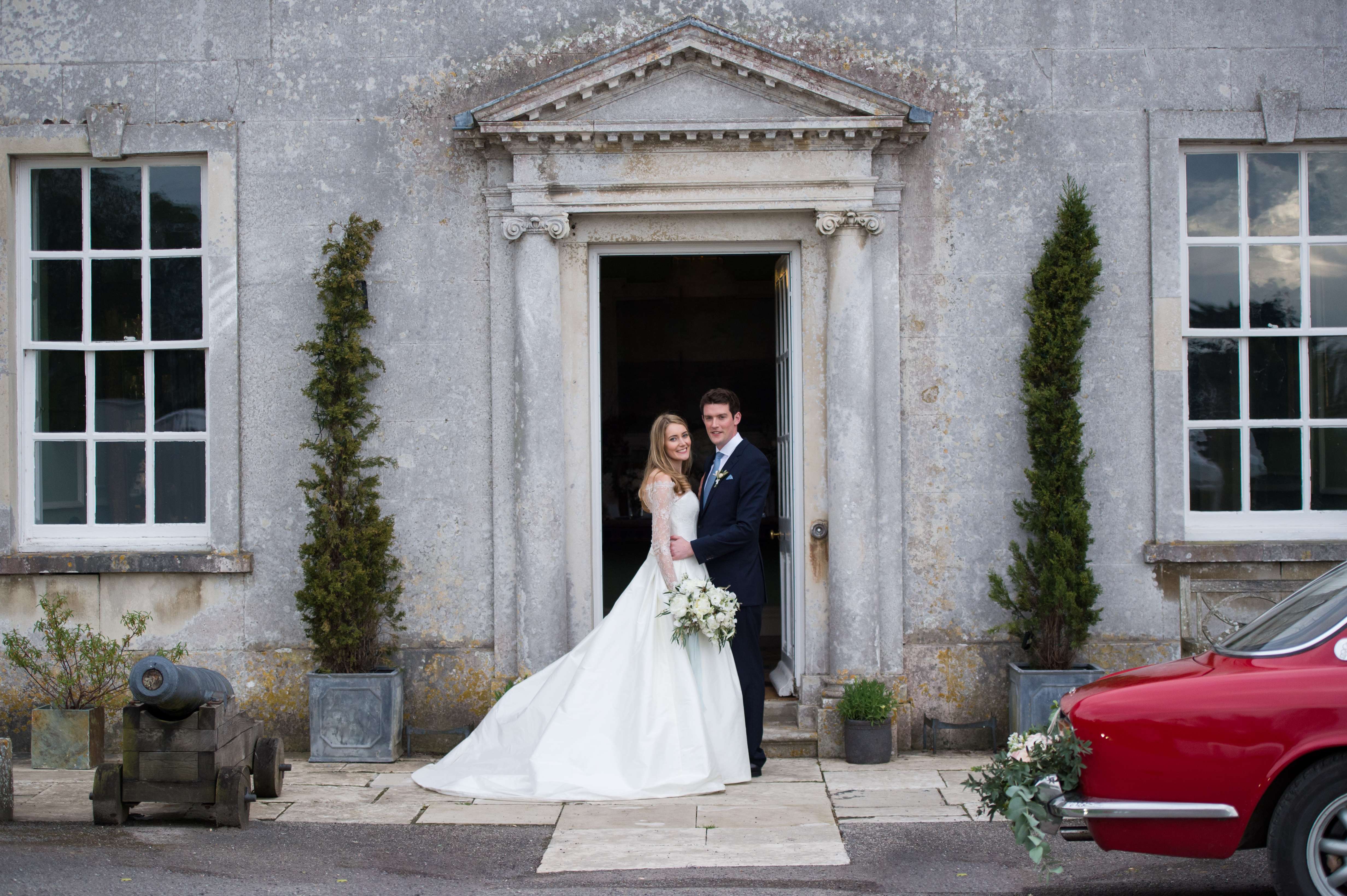 bride and groom in the doorway at smedmore house dorset by especially amy wedding photography